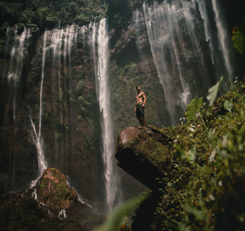 man standing in front of water fall